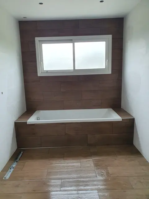 Photo de carrelage imitation bois sur mur et sol (salle de bain).