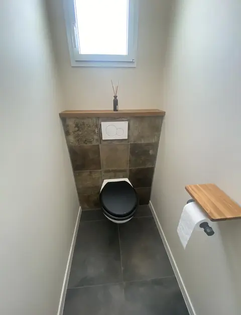 Photo de combinaison carrelage sur sol et arrière mur (toilettes).